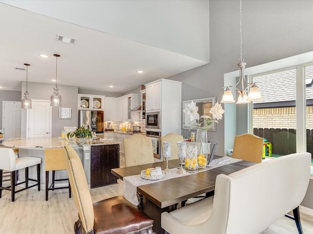 dining space with recessed lighting, visible vents, a notable chandelier, and light wood finished floors