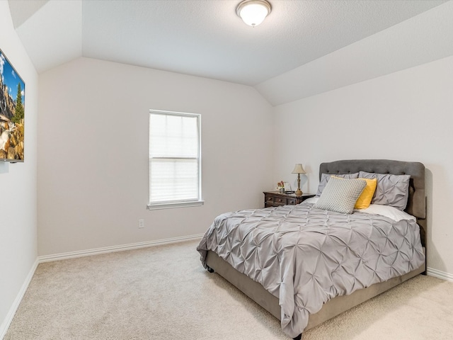 carpeted bedroom with lofted ceiling and baseboards