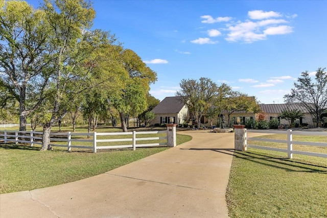 view of property's community with fence and a lawn