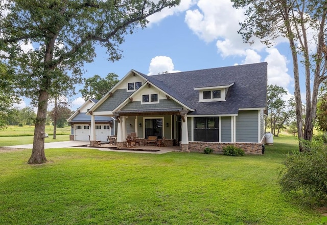 craftsman-style house with a garage, a front lawn, concrete driveway, and brick siding