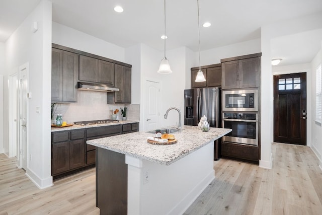 kitchen with under cabinet range hood, dark brown cabinets, stainless steel appliances, and a sink