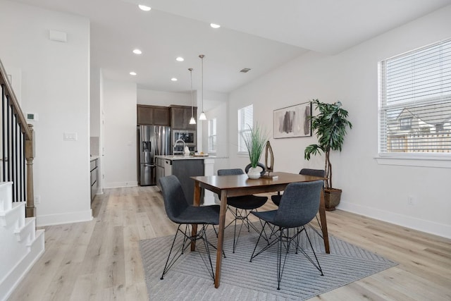 dining area featuring light wood-type flooring, plenty of natural light, stairway, and recessed lighting