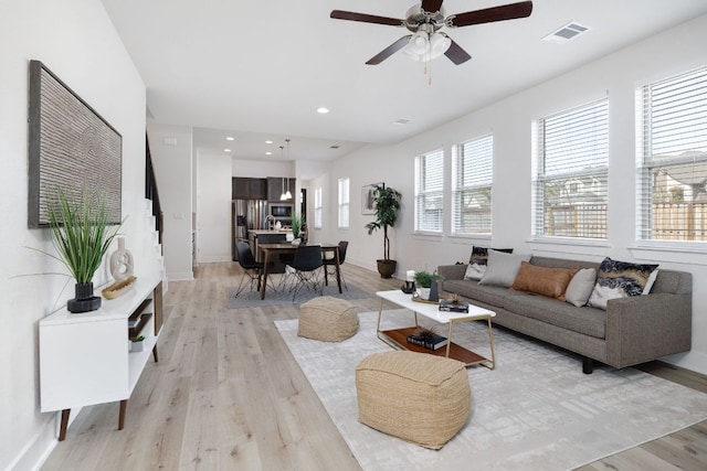 living area with light wood-style floors, baseboards, visible vents, and recessed lighting