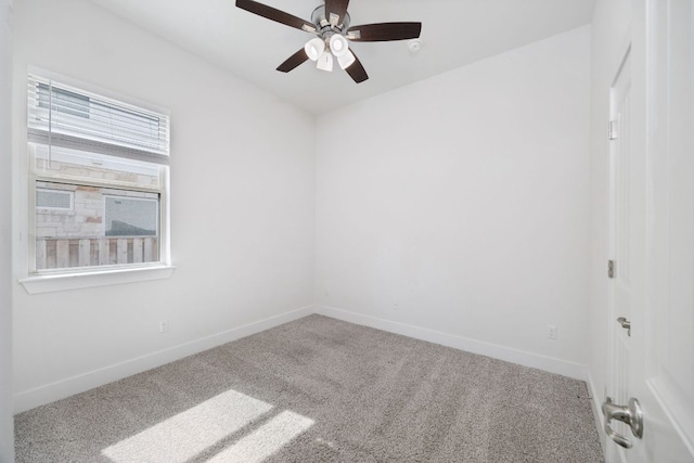 carpeted empty room featuring a ceiling fan and baseboards