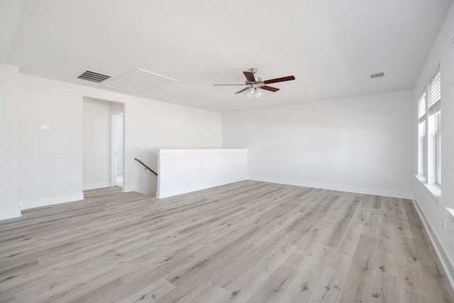 spare room featuring a ceiling fan, visible vents, light wood-style flooring, and baseboards