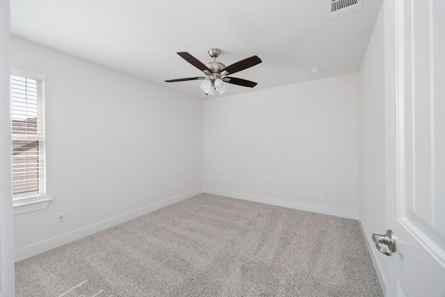 spare room with carpet, visible vents, ceiling fan, and baseboards