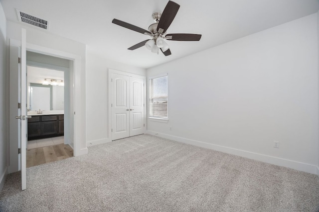 unfurnished bedroom with light carpet, a ceiling fan, visible vents, baseboards, and a closet