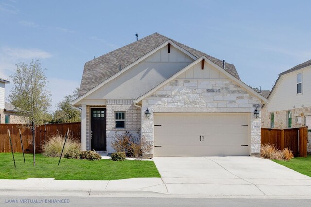 1409 Kneehigh Ln, Georgetown, TX 78633 - view of front facade featuring board and batten siding, a garage, stone siding, and driveway