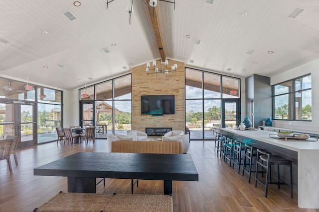 1409 Kneehigh Ln, Georgetown, TX 78633 - living area with high vaulted ceiling, a large fireplace, wood finished floors, expansive windows, and a wood ceiling with exposed beams
