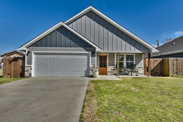 view of front facade featuring concrete driveway, board and batten siding, fence, a garage, and a front lawn