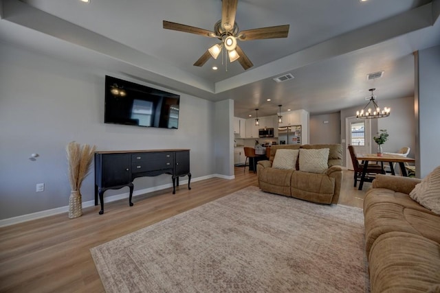 living area with light wood-type flooring, visible vents, and baseboards