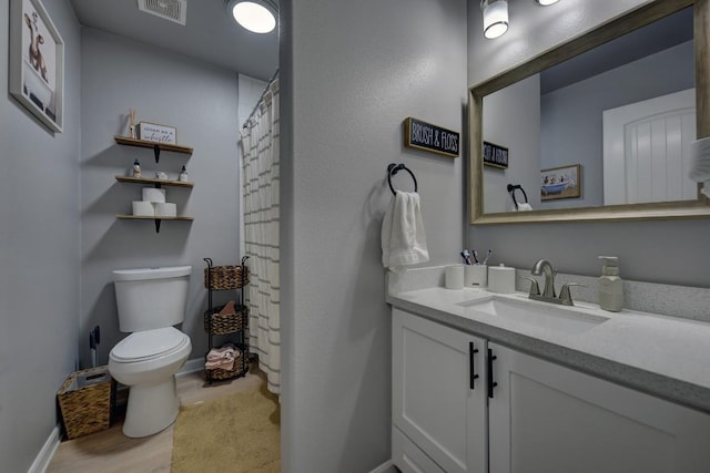 bathroom featuring curtained shower, toilet, wood finished floors, visible vents, and vanity