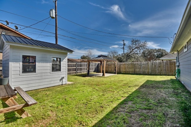 view of yard with a fenced backyard, an outbuilding, and a gazebo