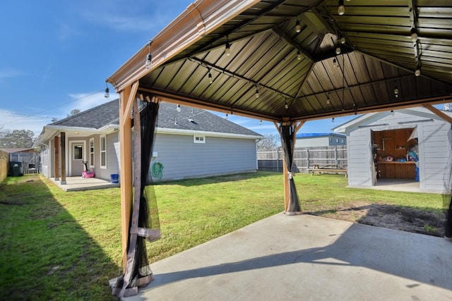 view of patio featuring a storage shed, a gazebo, an outdoor structure, and fence