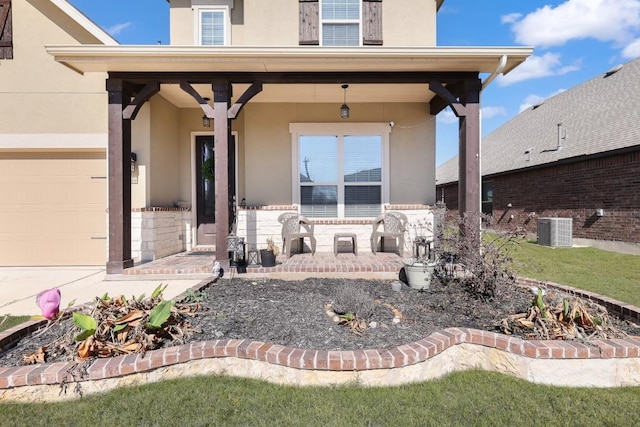 property entrance featuring a garage, central AC unit, and stucco siding