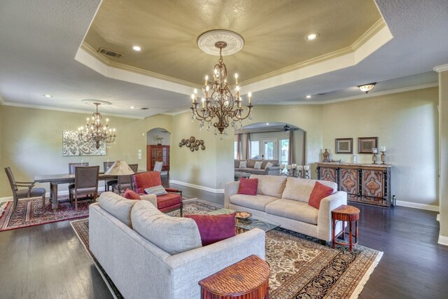 606 Free Rein, Horseshoe Bay, TX 78657 - living area featuring arched walkways, a raised ceiling, a chandelier, dark wood-type flooring, and ornamental molding