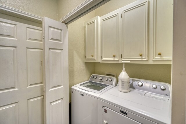 606 Free Rein, Horseshoe Bay, TX 78657 - laundry area with separate washer and dryer, a textured wall, and cabinet space