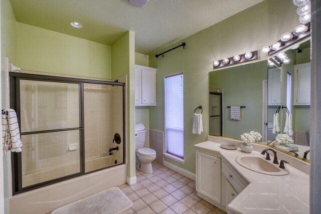 606 Free Rein, Horseshoe Bay, TX 78657 - full bath featuring toilet, vanity, tile patterned flooring, enclosed tub / shower combo, and baseboards