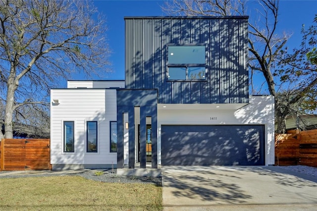 contemporary home with a garage, fence, and concrete driveway