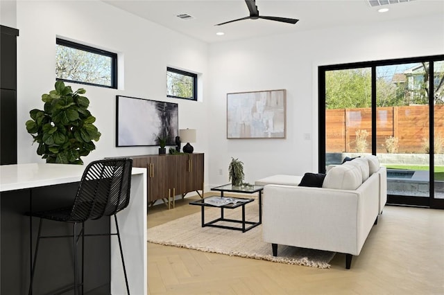 living area featuring a ceiling fan, visible vents, a wealth of natural light, and recessed lighting