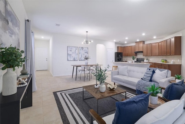 living room featuring light tile patterned floors, arched walkways, a chandelier, recessed lighting, and visible vents