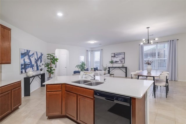 kitchen featuring arched walkways, black dishwasher, light countertops, and a sink