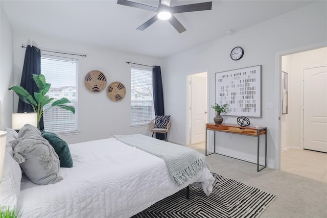 bedroom with light carpet, baseboards, and a ceiling fan