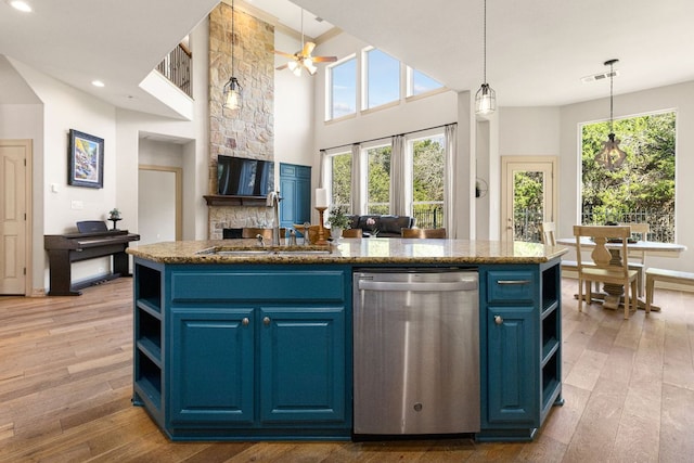 kitchen with blue cabinets, hardwood / wood-style flooring, open shelves, and stainless steel dishwasher