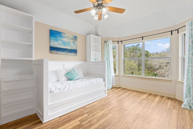 sitting room with a ceiling fan, lofted ceiling, baseboards, and wood finished floors