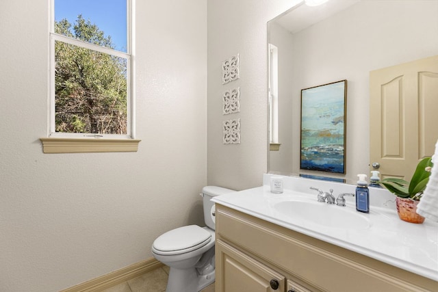 half bath featuring baseboards, vanity, toilet, and tile patterned floors