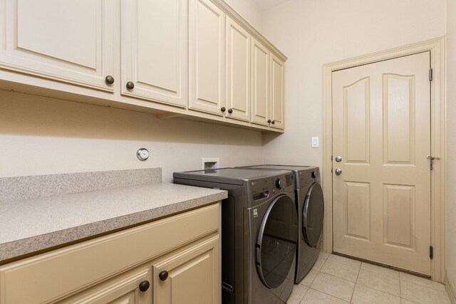 washroom featuring cabinet space, separate washer and dryer, and light tile patterned flooring