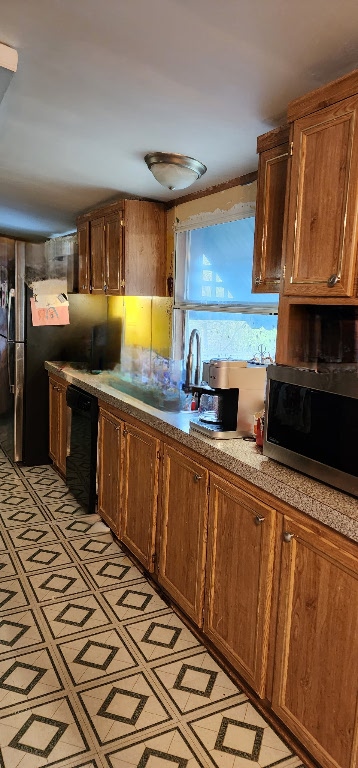 kitchen with light floors, light countertops, stainless steel microwave, a sink, and dishwasher