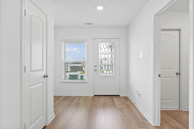 foyer featuring baseboards, visible vents, and light wood finished floors