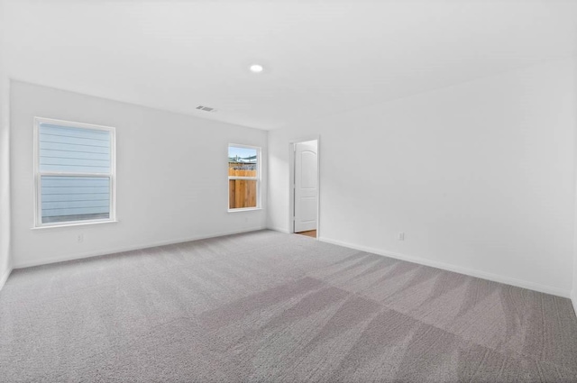 carpeted spare room with baseboards, visible vents, and recessed lighting