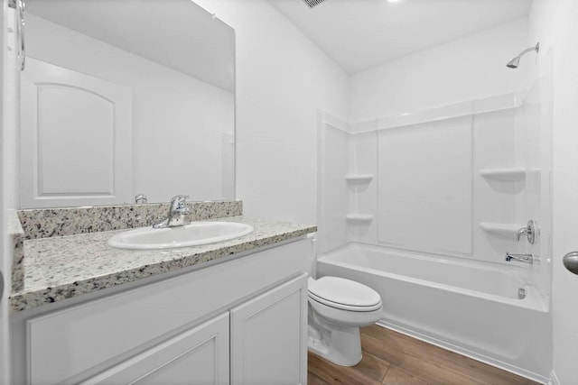 full bath featuring shower / bathtub combination, vanity, toilet, and wood finished floors