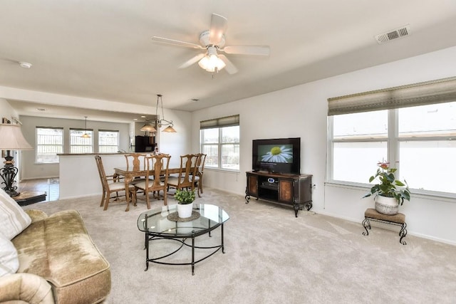 living room featuring a healthy amount of sunlight, visible vents, and light carpet