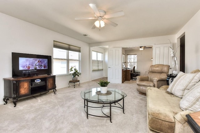 carpeted living area featuring a ceiling fan and a wealth of natural light