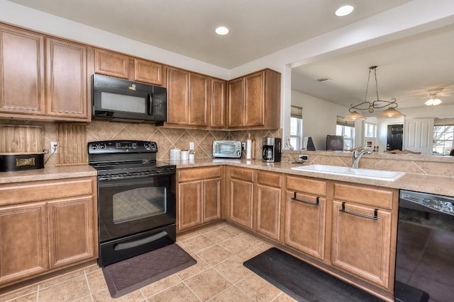 kitchen with decorative backsplash, brown cabinets, light countertops, black appliances, and a sink