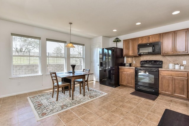 kitchen featuring light countertops, backsplash, brown cabinets, black appliances, and decorative light fixtures