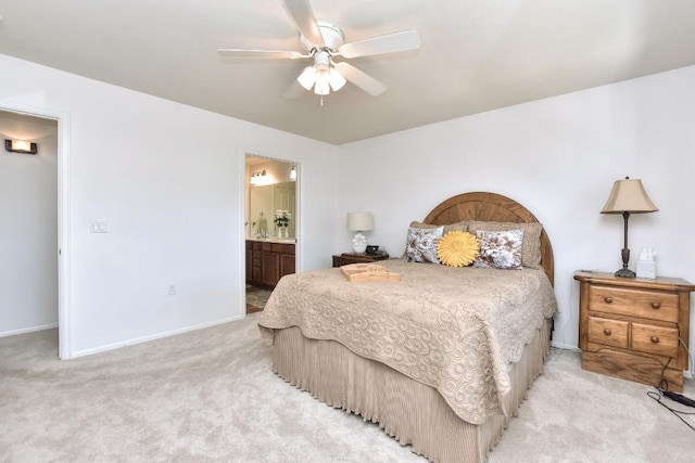 bedroom featuring light carpet, a ceiling fan, baseboards, and connected bathroom