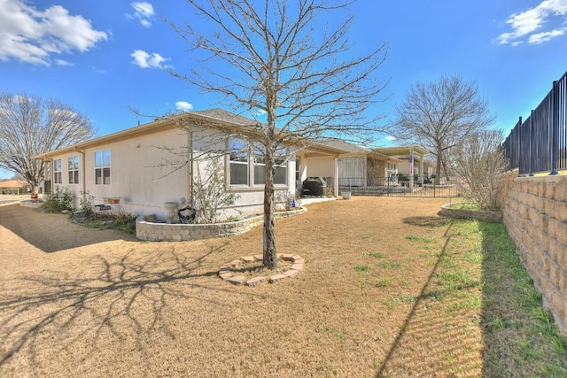 back of house featuring fence and a lawn