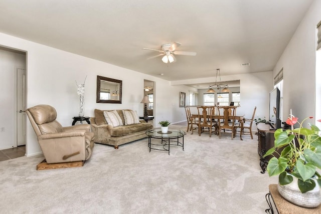 living area with carpet floors, visible vents, and a ceiling fan