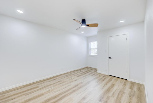 spare room featuring recessed lighting, ceiling fan, light wood-style flooring, and baseboards