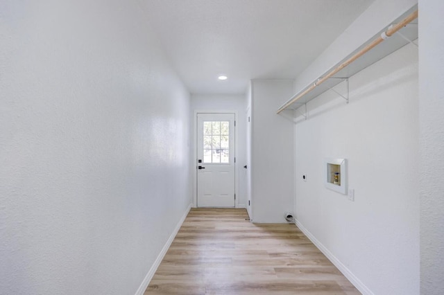 clothes washing area featuring washer hookup, light wood finished floors, electric dryer hookup, laundry area, and baseboards