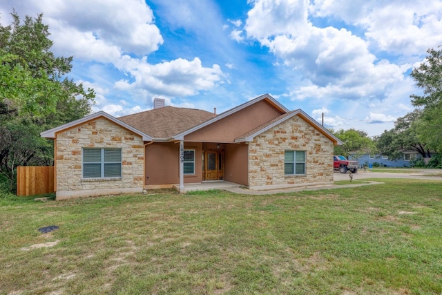 ranch-style home with stone siding, a chimney, fence, and a front yard