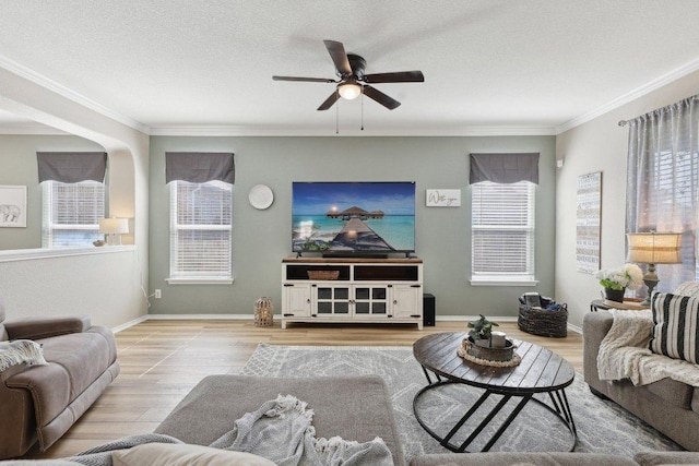 living area with a healthy amount of sunlight, baseboards, ornamental molding, and wood finished floors