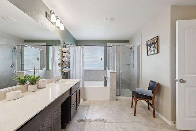 bathroom with a textured ceiling, vanity, a bath, tile patterned floors, and a stall shower