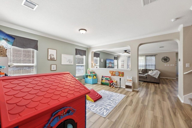 bedroom featuring arched walkways, crown molding, and wood finished floors