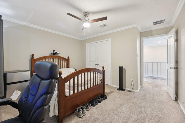 bedroom featuring crown molding, a closet, visible vents, light carpet, and baseboards