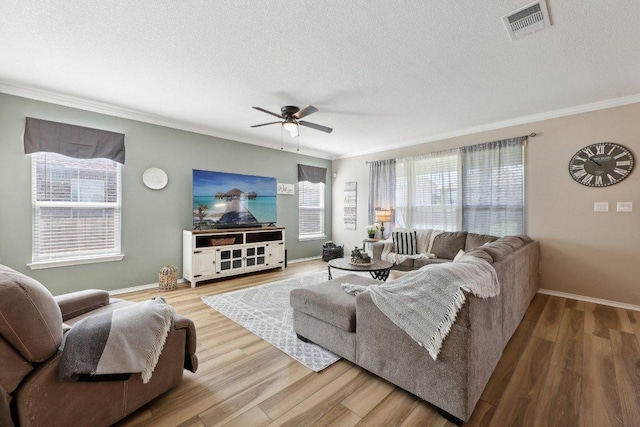 living area with light wood-type flooring, visible vents, and a textured ceiling